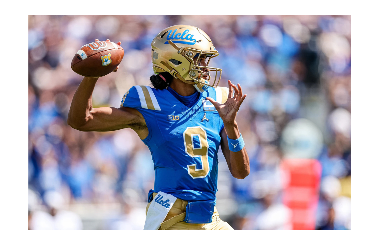 A UCLA football quarterback wearing jersey number 9, a gold helmet, and a light blue jersey winds up to throw a football, with the stadium crowd blurred in the background.